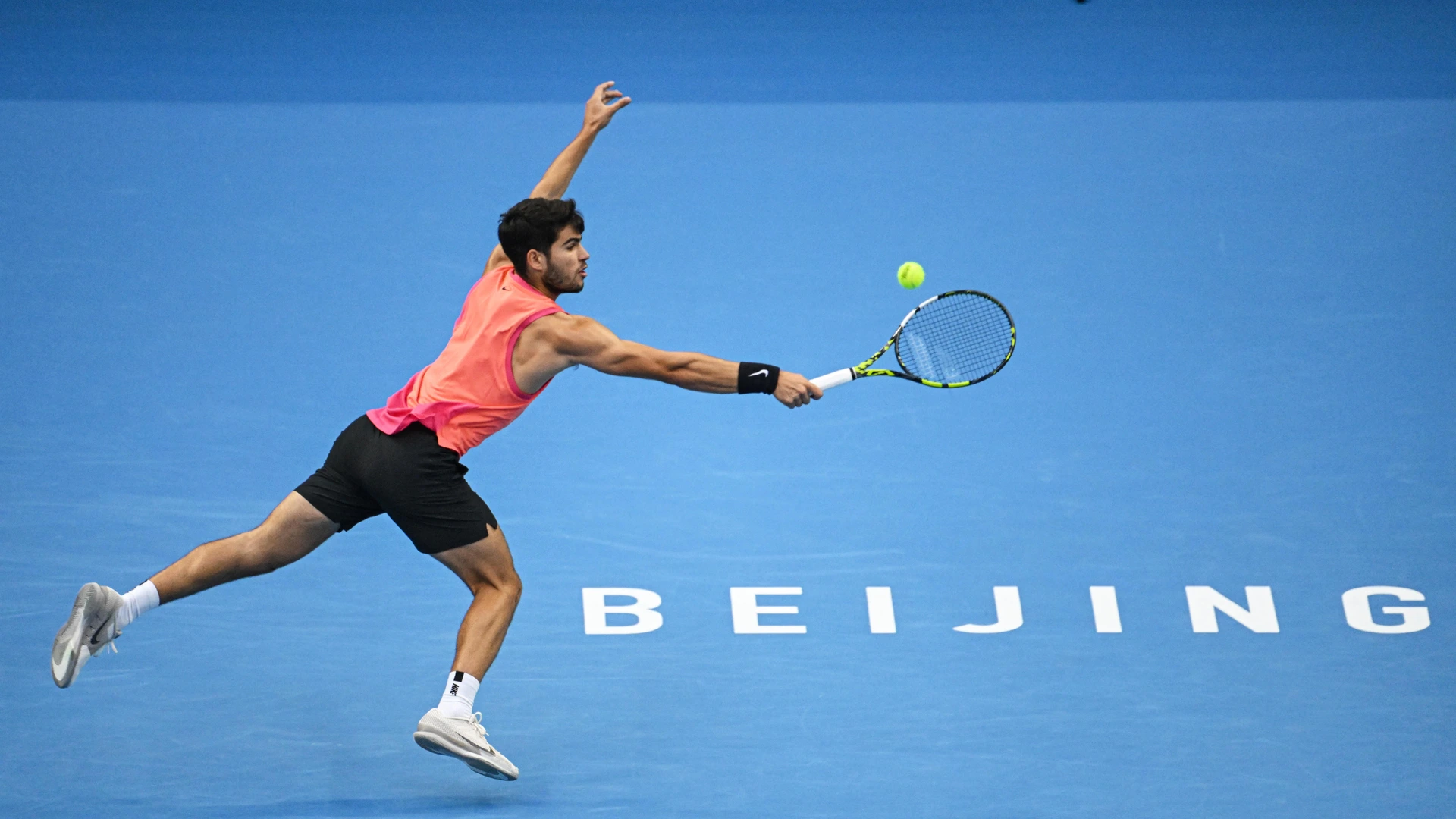 Spain’s Carlos Alcaraz hits a return to Russia's Karen Khachanov during their men’s singles quarter-final match at the China Open tennis tournament in Beijing on September 30, 2024.
