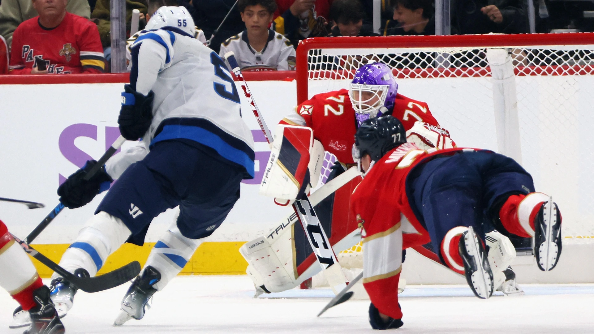 Niko Mikkola #77 and Sergei Bobrovsky #72 of the Florida Panthers combine to stop Mark Scheifele #55 of the Winnipeg Jets during the second period at Amerant Bank Arena on November 16, 2024