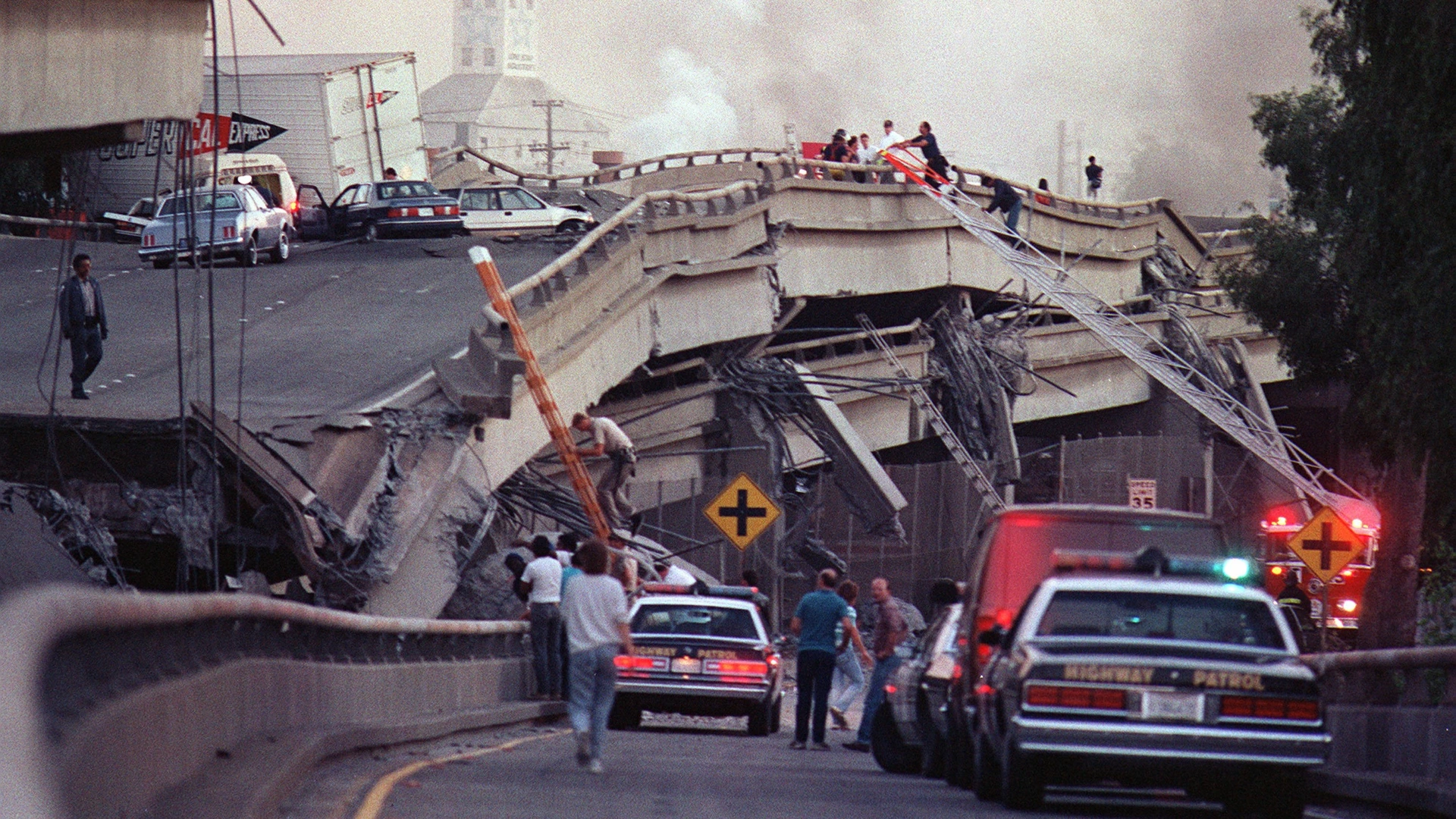 Rescue workers and police enter the scene of destruction where the Interstate 880-Interstate 80 interchange collapsed in Oakland during the Loma Prieta earthquake in October 1989.