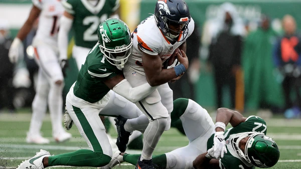 EAST RUTHERFORD, NEW JERSEY - SEPTEMBER 29: Javonte Williams #33 of the Denver Broncos rushes against Sauce Gardner #1 of the New York Jets and Tony Adams #22 of the New York Jets during the fourth quarter at MetLife Stadium on September 29, 2024