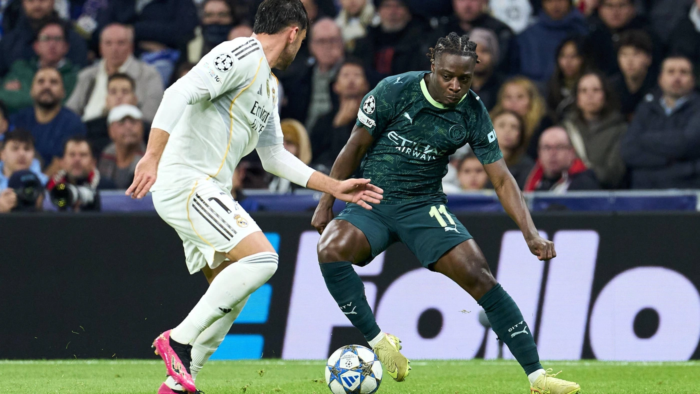 Jeremy Doku of Manchester City FC battles for the ball with Raul Asencio of Real Madrid CF during the UEFA CHAMPIONS LEAGUE match between Real Madrid CF and Manchester City FC at Bernabeu stadium on December 10, 2025.