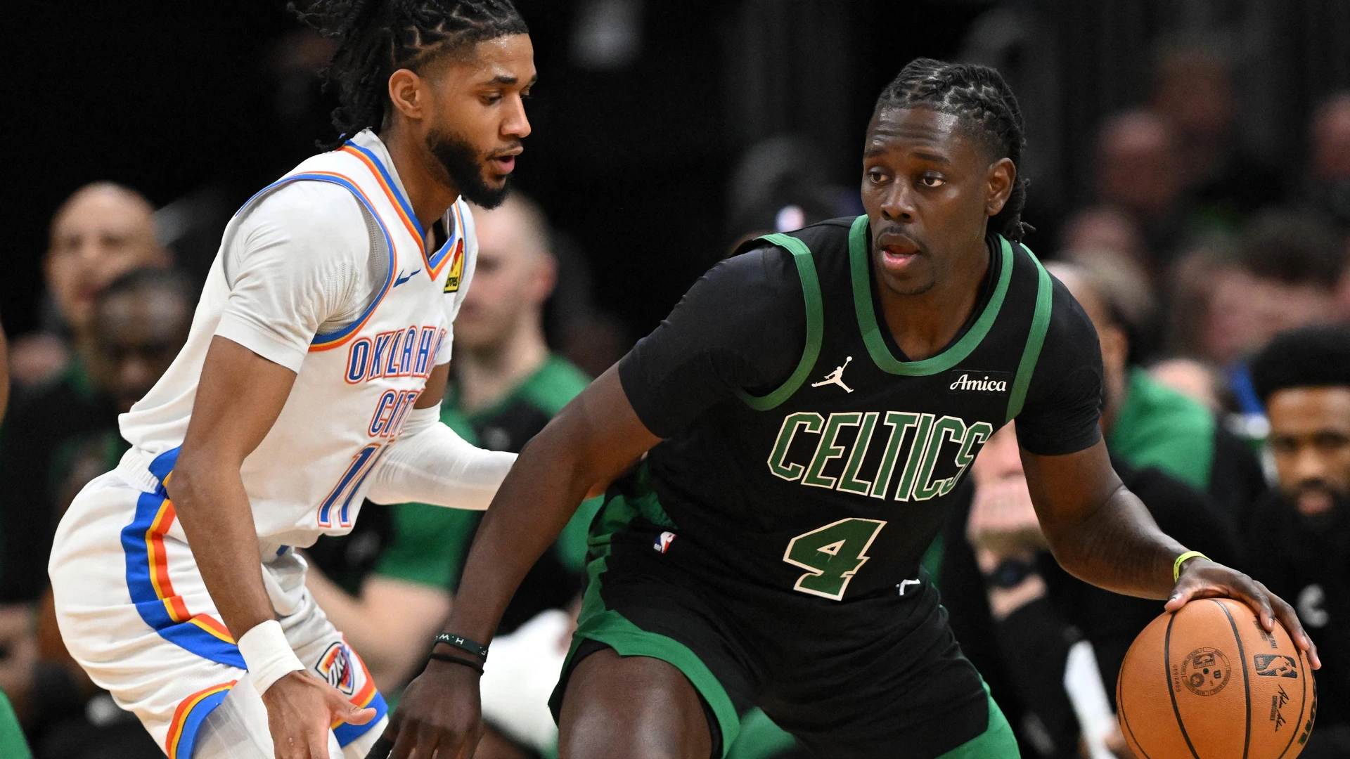 BOSTON, MASSACHUSETTS - MARCH 12: Jrue Holiday #4 of the Boston Celtics goes to the basket against Isaiah Joe #11 of the Oklahoma City Thunder during the fourth quarter at the TD Garden on March 12, 2025 in Boston, Massachusetts.