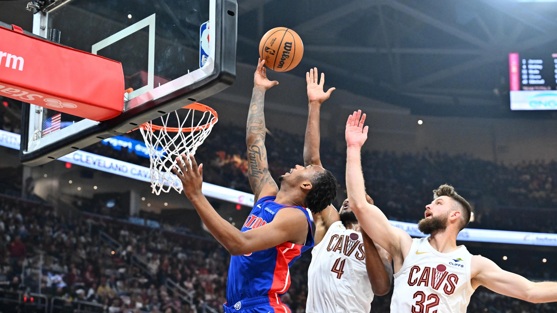 CLEVELAND, OHIO - OCTOBER 25: Ronald Holland II #00 of the Detroit Pistons shoots over Evan Mobley #4 and Dean Wade #32 of the Cleveland Cavaliers during the second quarter at Rocket Mortgage Fieldhouse on October 25, 2024 in Cleveland, Ohio.