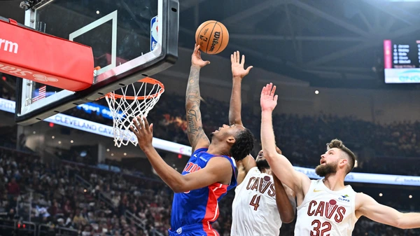 CLEVELAND, OHIO - OCTOBER 25: Ronald Holland II #00 of the Detroit Pistons shoots over Evan Mobley #4 and Dean Wade #32 of the Cleveland Cavaliers during the second quarter at Rocket Mortgage Fieldhouse on October 25, 2024 in Cleveland, Ohio.