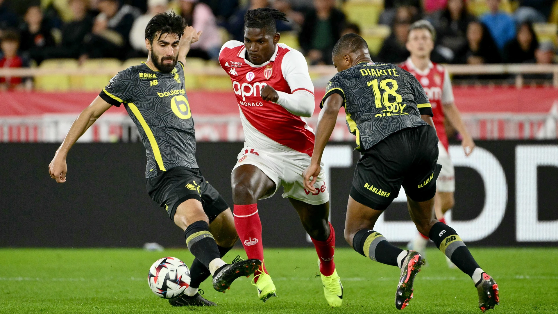Monaco's Breel Embolo (C) fights for the ball with Lille's Bafode Diakite (R) and Lille's Andre Gomes (L) during the French L1 football match between Monaco (ASM) and Lille LOSC at the Louis-II Stadium in Monaco on October 18, 2024.