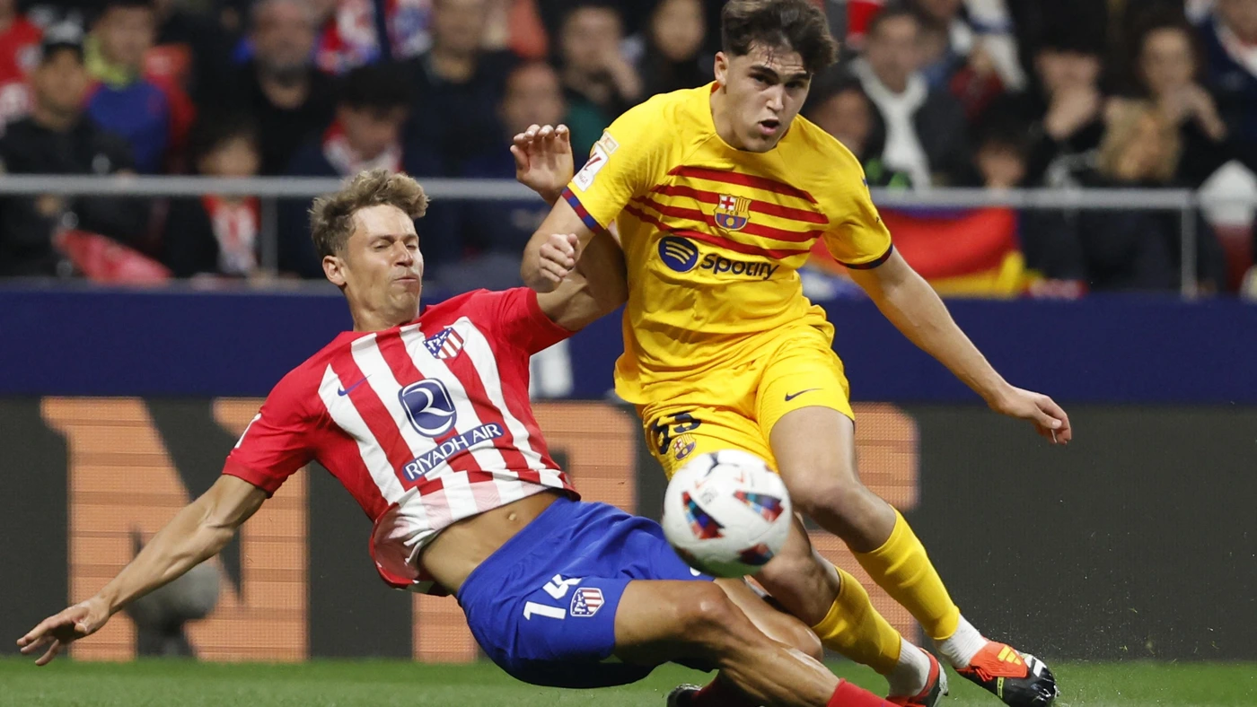 Atletico Madrid's midfielder #14 Marcos Llorente (L) tackles Barcelona's defender #33 Pau Cubarsi during the Spanish league football match between Club Atletico de Madrid and FC Barcelona at the Metropolitano stadium in Madrid on March 17, 2024.