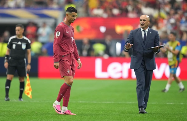 (260707) -- DALLAS, July 7, 2026 -- Cristiano Ronaldo (L) of Portugal and Roberto Martinez, coach of Portugal, react after the round of 16 match between Spain and Portugal at the 2026 FIFA World Cu...
