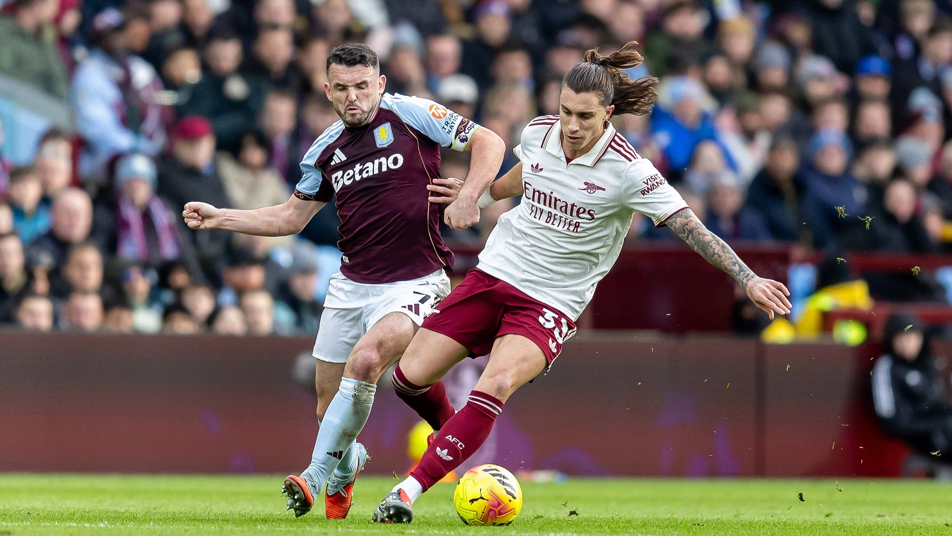 Aston Villa midfielder John McGinn 7 battles for possession with Arsenal defender Riccardo Calafiori 33 during the Premier League match between Aston Villa and Arsenal at Villa Park, on 6 December 2025.