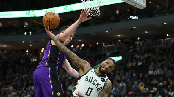 MILWAUKEE, WISCONSIN - MARCH 13: Damian Lillard #0 of the Milwaukee Bucks is fouled by Dalton Knecht #4 of the Los Angeles Lakers during the first half of a game at Fiserv Forum on March 13, 2025 in Milwaukee, Wisconsin.