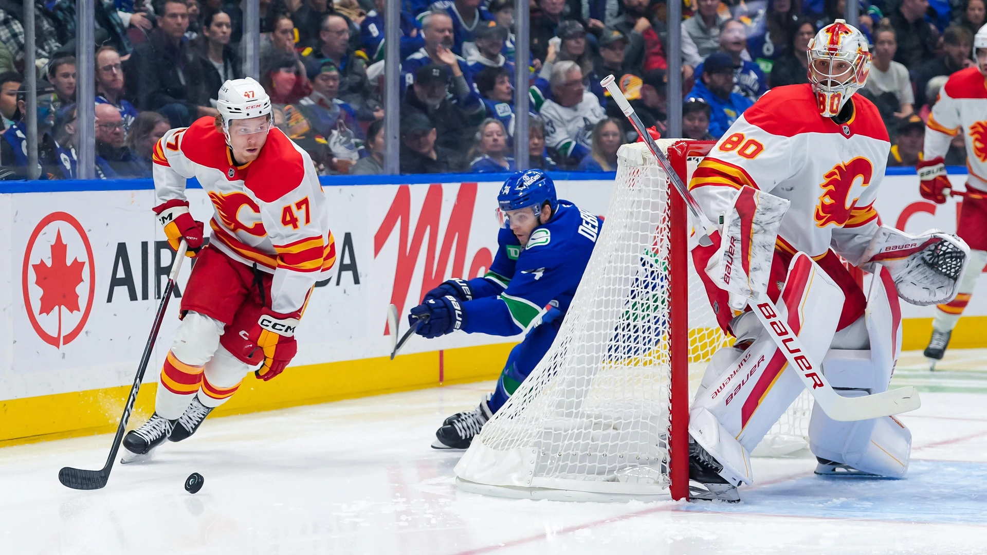 VANCOUVER, CANADA - OCTOBER 9: Connor Zary #47 of the Calgary Flames is pursued by Jake DeBrusk #74 of the Vancouver Canucks during the first period of their NHL game at Rogers Arena on October 9, 2024 in Vancouver, British Columbia, Canada.
