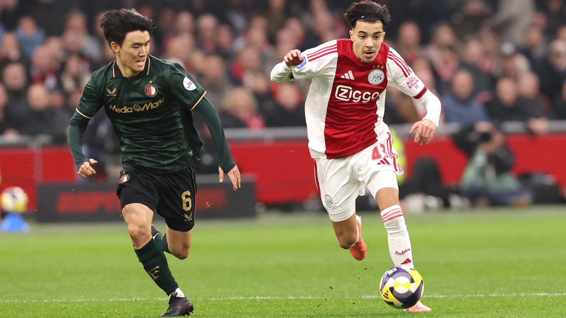 Rayane Bounida of AFC Ajax with Inbeom Hwang of Feyenoord Rotterdam during the match AFC Ajax Amsterdam vs Feyenoord Rotterdam at the Johan Cruijff ArenA for the Dutch Eredivisie season 2025-2026 in AMSTERDAM, Netherlands on 14 december 2025.
