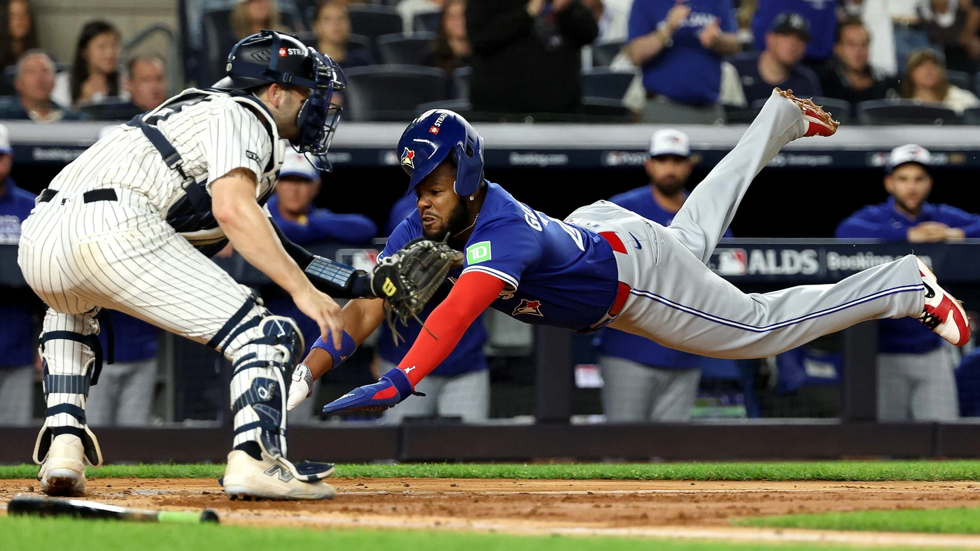 Vladimir Guerrero Jr. #27 of the Toronto Blue Jays slides safely into home plate to score against Austin Wells #28 of the New York Yankees during the third inning in game 3of the American League Division Series at Yankee Stadium on October 07, 2025