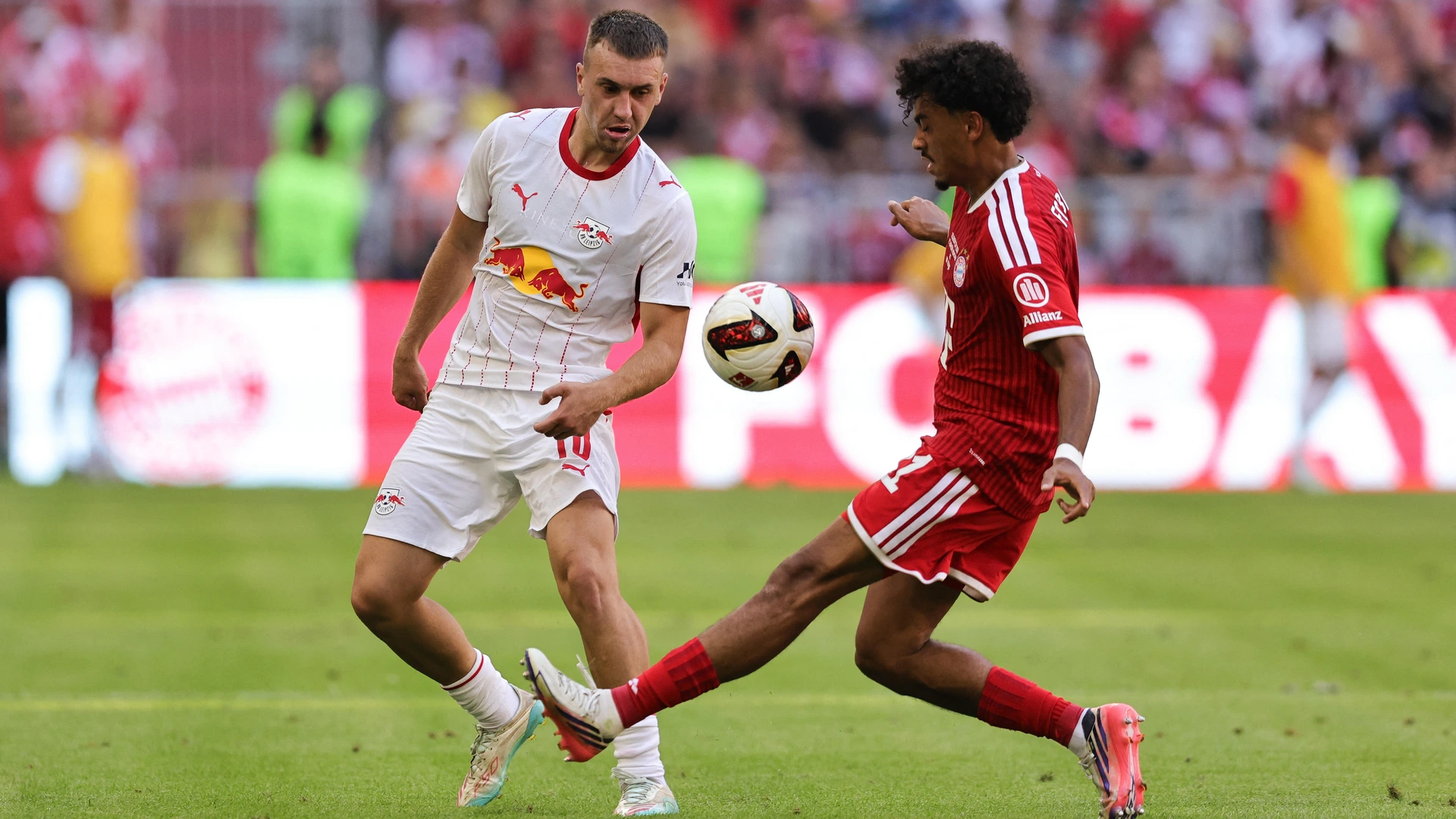 15.08.2026 Football, Bundesliga, FC Bayern Munich - RB Leipzig, Brajan Gruda of RB Leipzig Nathaniel Brown of FC FC Bayern Munich compete for the ball