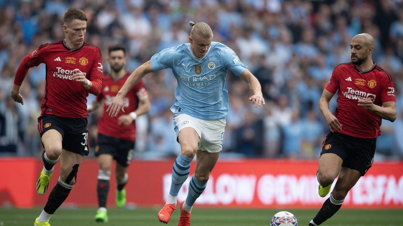 Erling Braut Haaland of Manchester City (centre) and Scott McTominay (left) and Sofyan Amrabat of Manchester United during the Emirates FA Cup Final match between Manchester City and Manchester United at Wembley Stadium on May 25, 2024 in London, England.