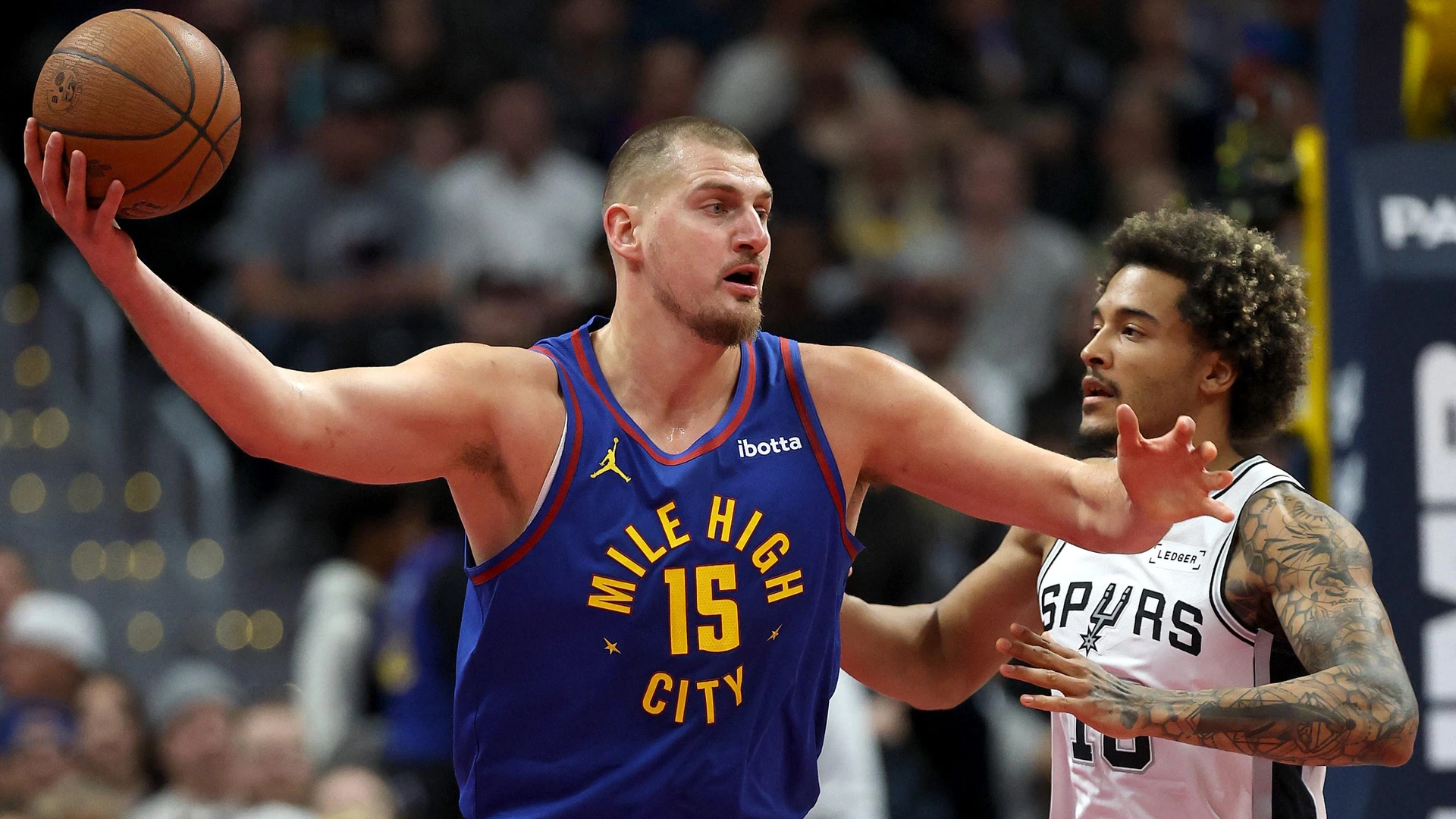 Nikola Jokic #15 of the Denver Nuggets is guarded by Jeremy Sochan #10 of the San Antonio Spurs on November 28, 2025 in Denver, Colorado.