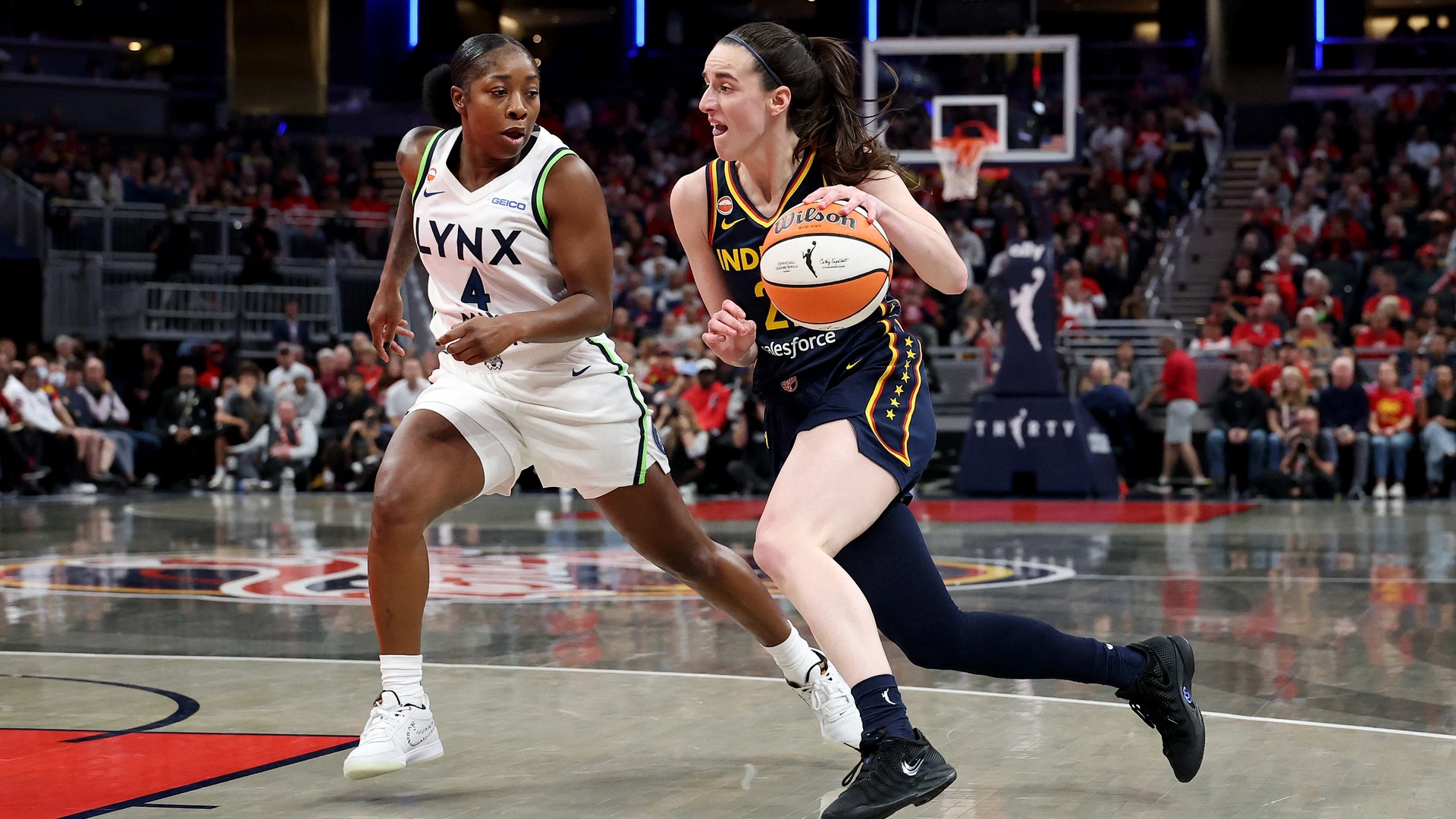 Caitlin Clark #22 of the Indiana Fever dribbles the ball while defended by Aari McDonald #4 of the Minnesota Lynx at Gainbridge Fieldhouse on September 22, 2026
