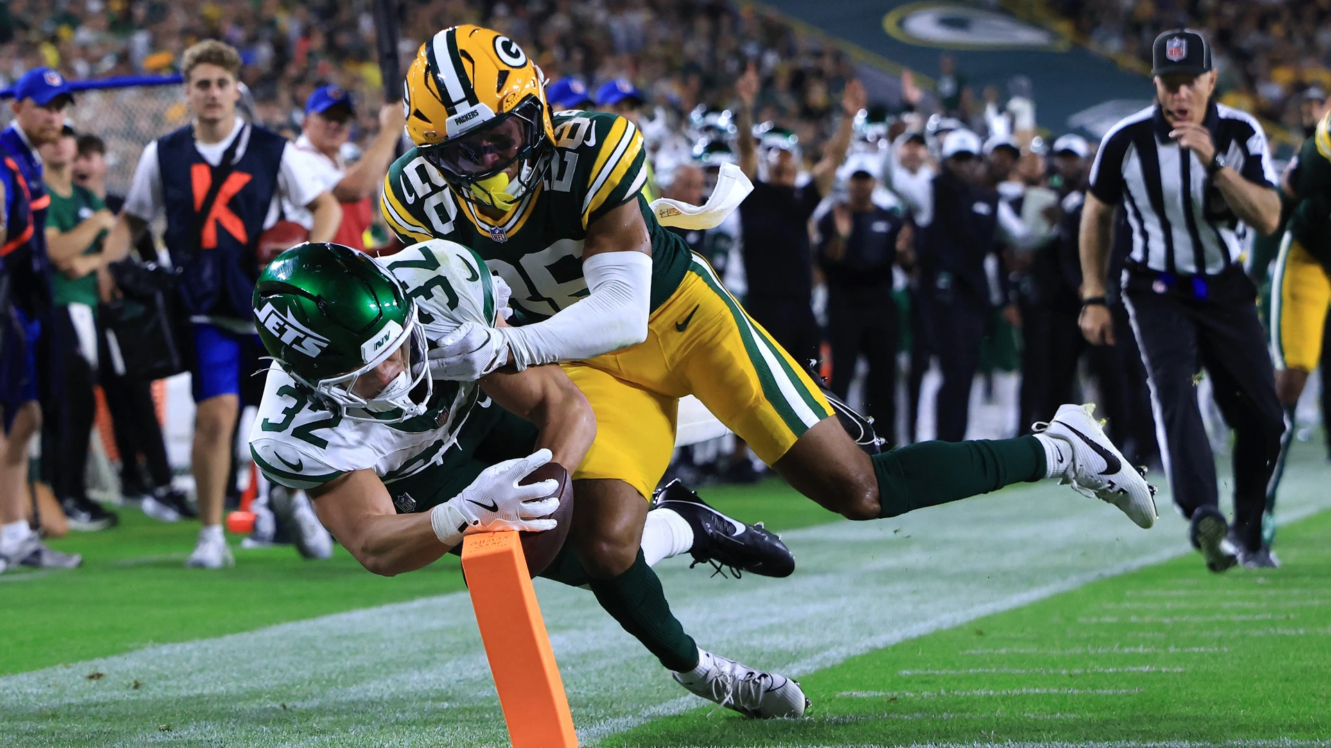 Isaiah Davis #32 of the New York Jets is pushed out of bounds by Micah Robinson #26 of the Green Bay Packers during the second quarter during the NFL Preseason 2025 game between New York Jets and Green Bay Packers at Lambeau Field on August 09, 2025